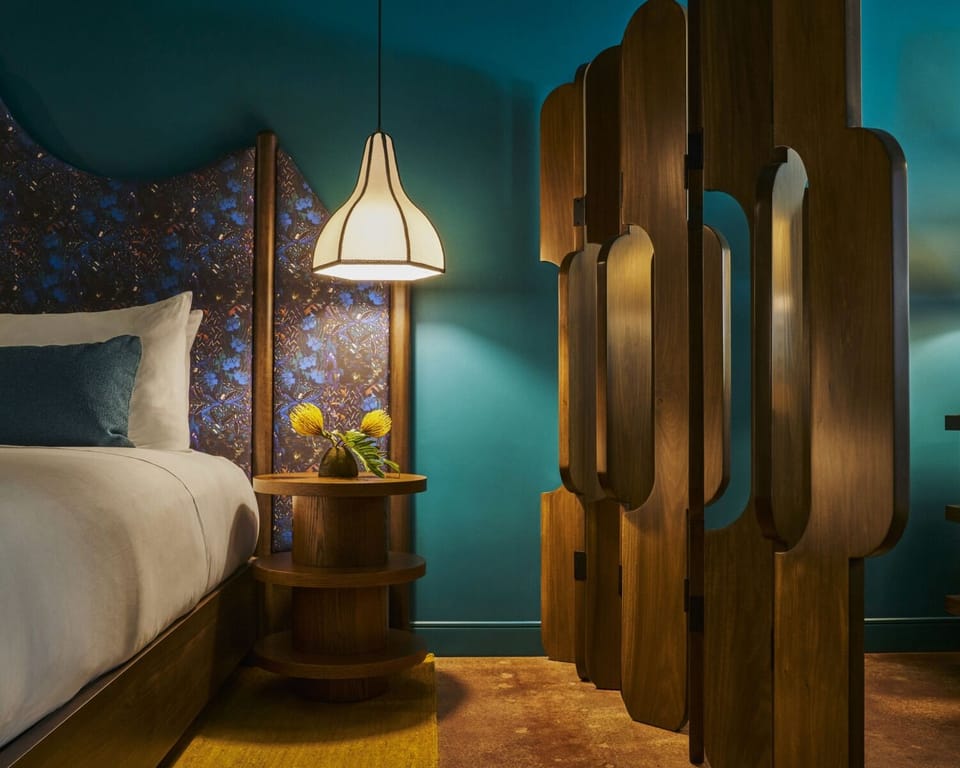 Unwind in a moody, design-led bedroom with warm glow.