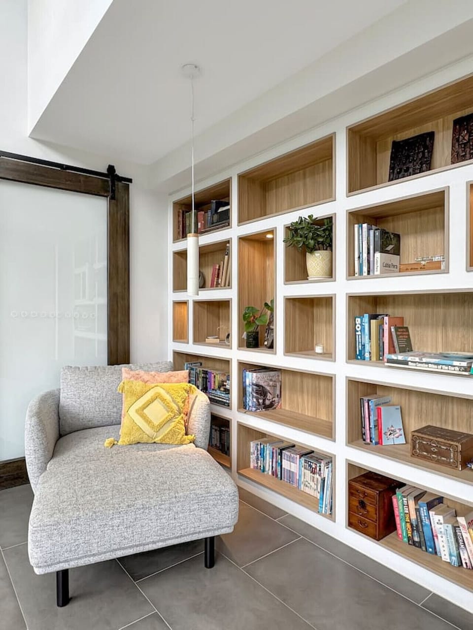 A quiet reading nook with custom built-in shelving and a comfortable lounge chair, perfect for relaxing with a book or enjoying a peaceful moment