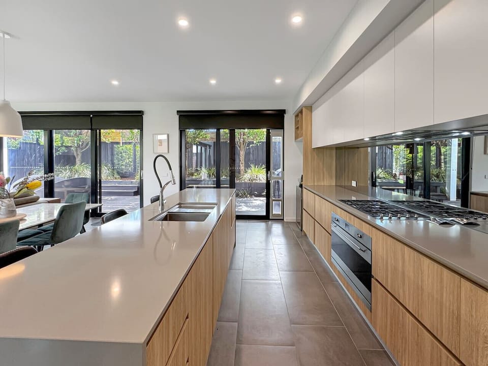 A stylish, light-filled kitchen with a generous island bench, quality appliances and easy access to the outdoor entertaining area