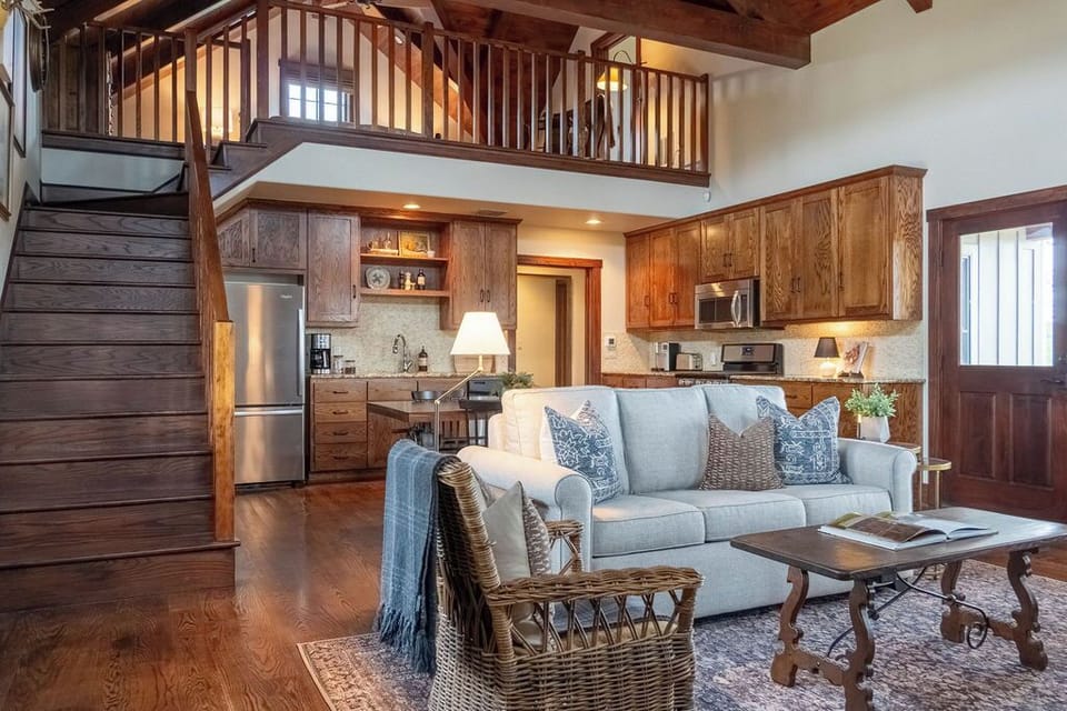 The living room, with soaring wood planked ceilings and a limestone fireplace.