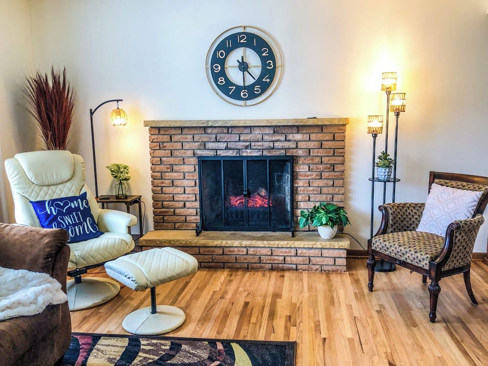 Living room with electric fireplace and vibrating massage chair.