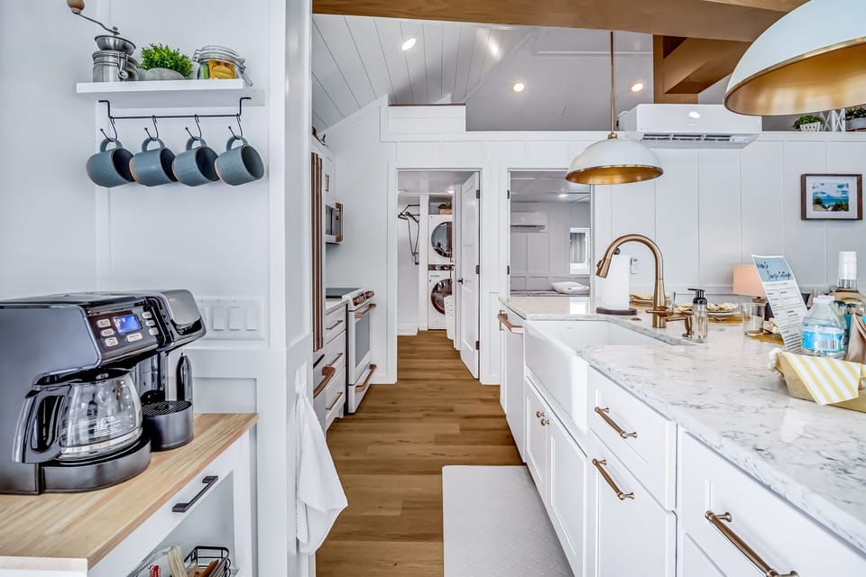 Large modern kitchen includes island counter with deep farmhouse sink