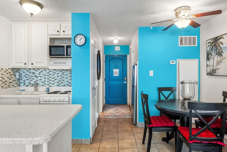 Fully stocked kitchen and dining area with cheerful coastal colors.