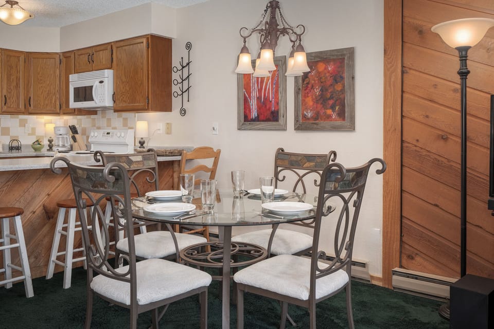 Gather around your elegant dining table beneath warm chandelier light, where home-cooked meals become cherished memories in this thoughtfully appointed space.