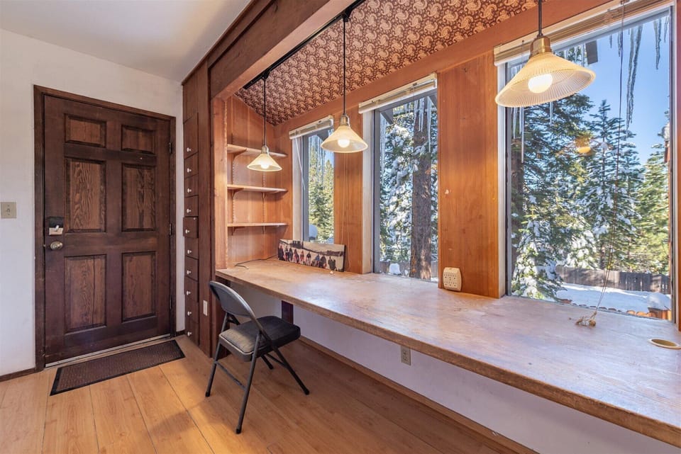 Your perfect workspace awaits with a built-in desk beneath forest views, where morning coffee and productivity blend seamlessly.