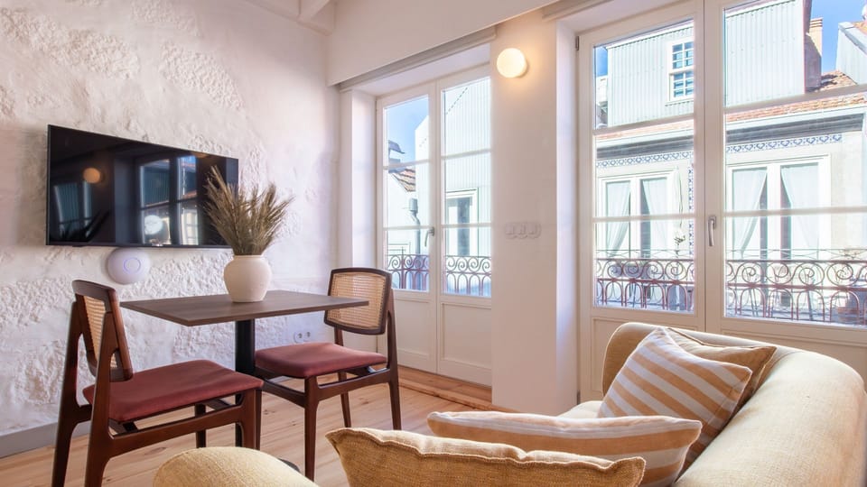 Sun-filled lounge with large windows and charming street views — ideal for both work and relaxation. #CityViews #RemoteWorkReady #PortugalStay”