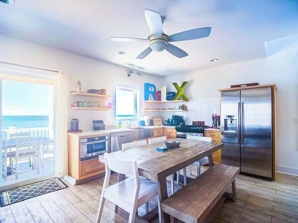 Open dining area set for shared meals, surrounded by light-filled coastal vibes.