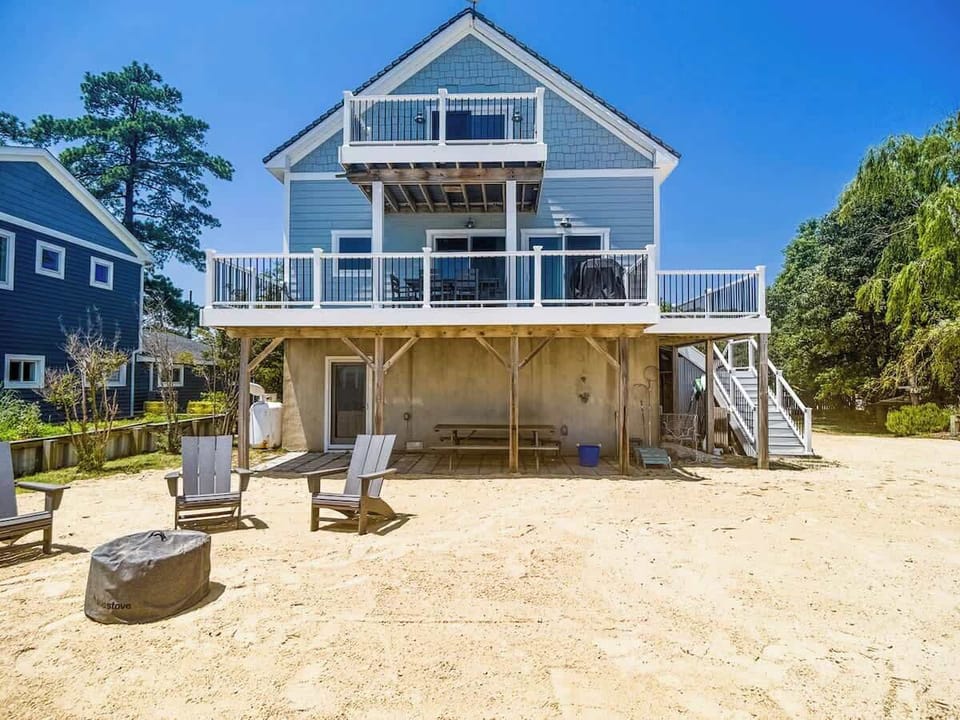 Beachfront exterior showcasing direct sand access & classic coastal charm.