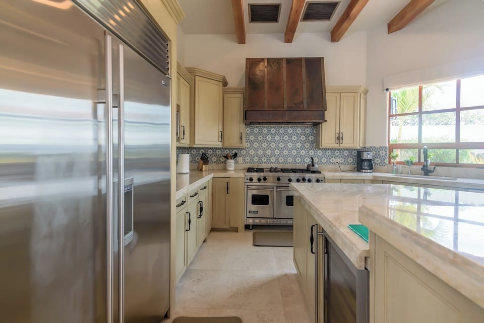 Fully equipped gourmet kitchen with high-end stainless steel appliances, custom cabinetry, and elegant backsplash design.