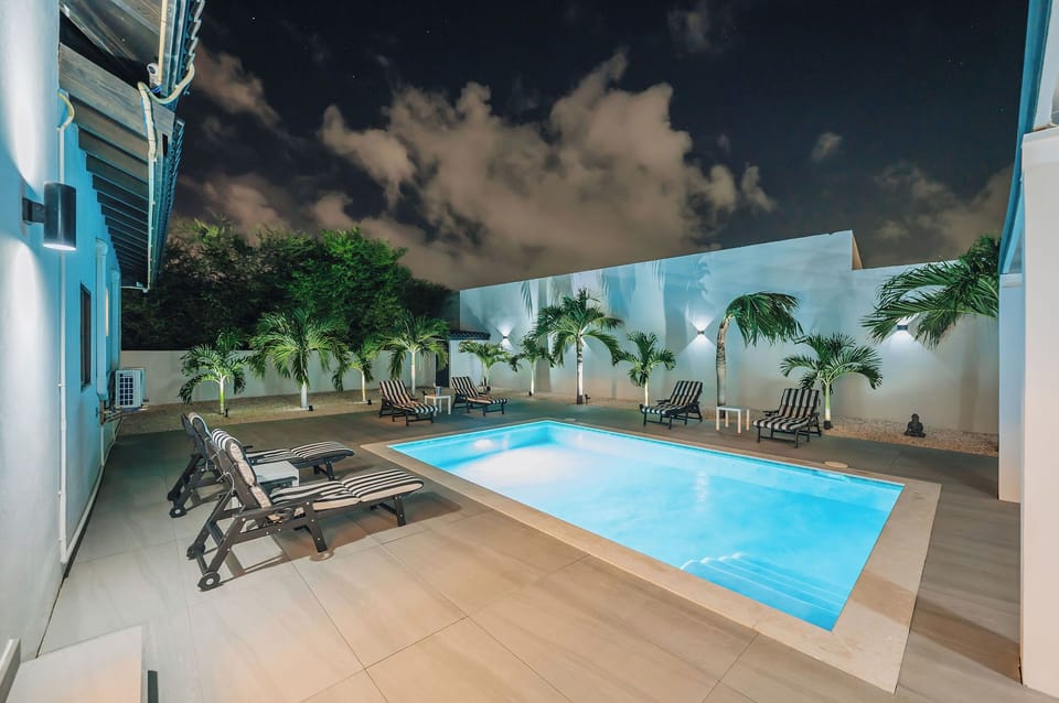 The Tides outdoor pool area at night, softly lit for relaxed evening swims and laid-back island nights.
