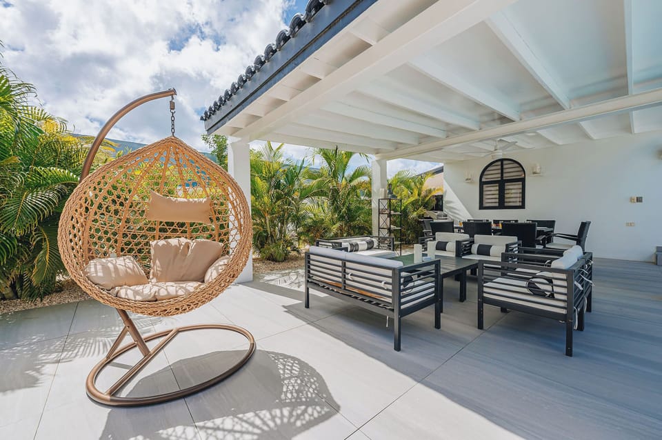 Covered outdoor lounge and dining space at The Tides, ideal for morning coffee, shade breaks, or long evenings together.