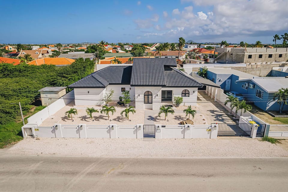Aerial view of The Tides showcasing the full villa layout, private pool, and spacious outdoor living areas.