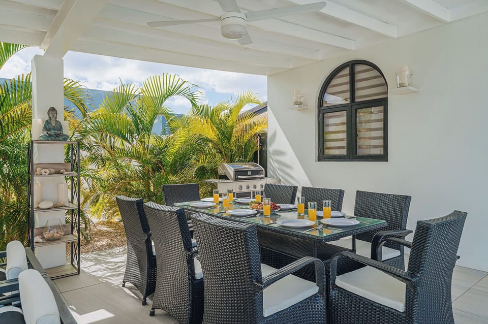 Outdoor dining setup with BBQ grill at The Tides, surrounded by tropical greenery for easy alfresco meals.