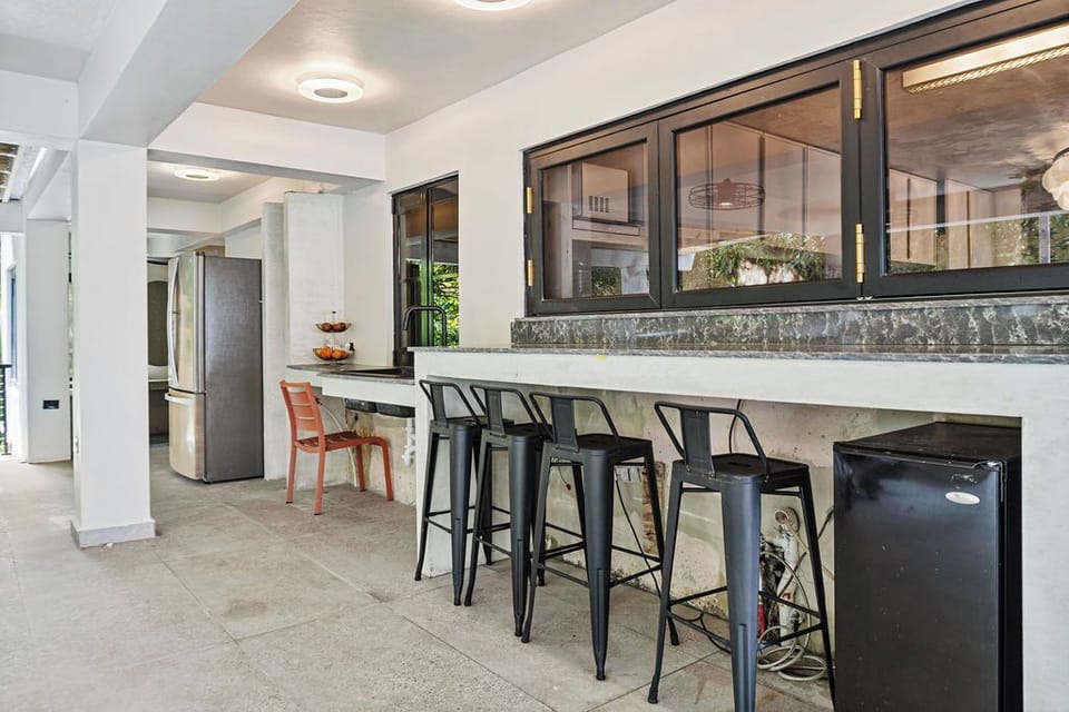 The accordion window seamlessly connects the outdoor bar to the indoor kitchen, making entertaining effortless and enjoyable.