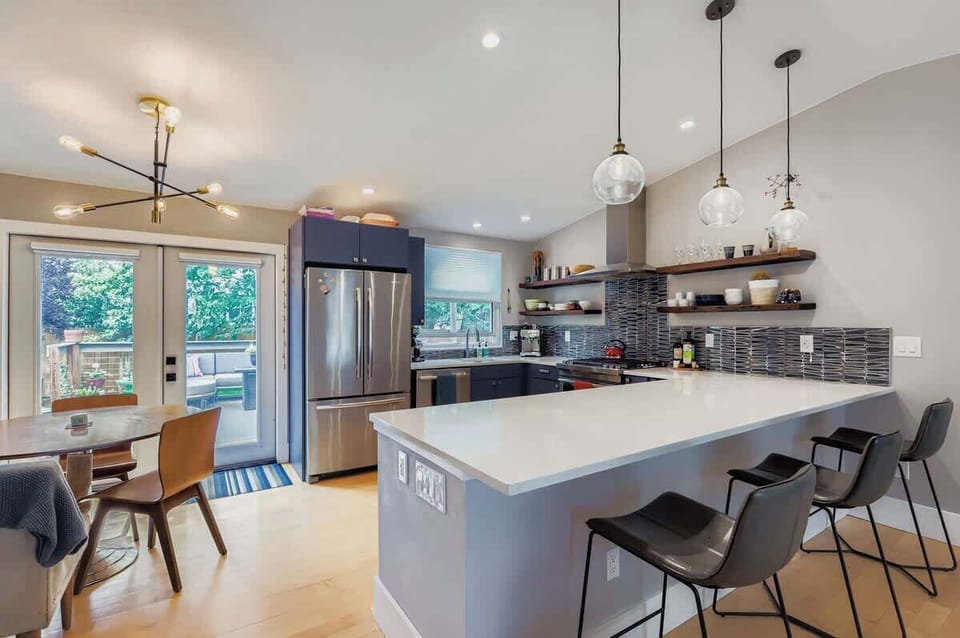 A modern kitchen featuring a cozy kitchen table and direct access to the backyard.