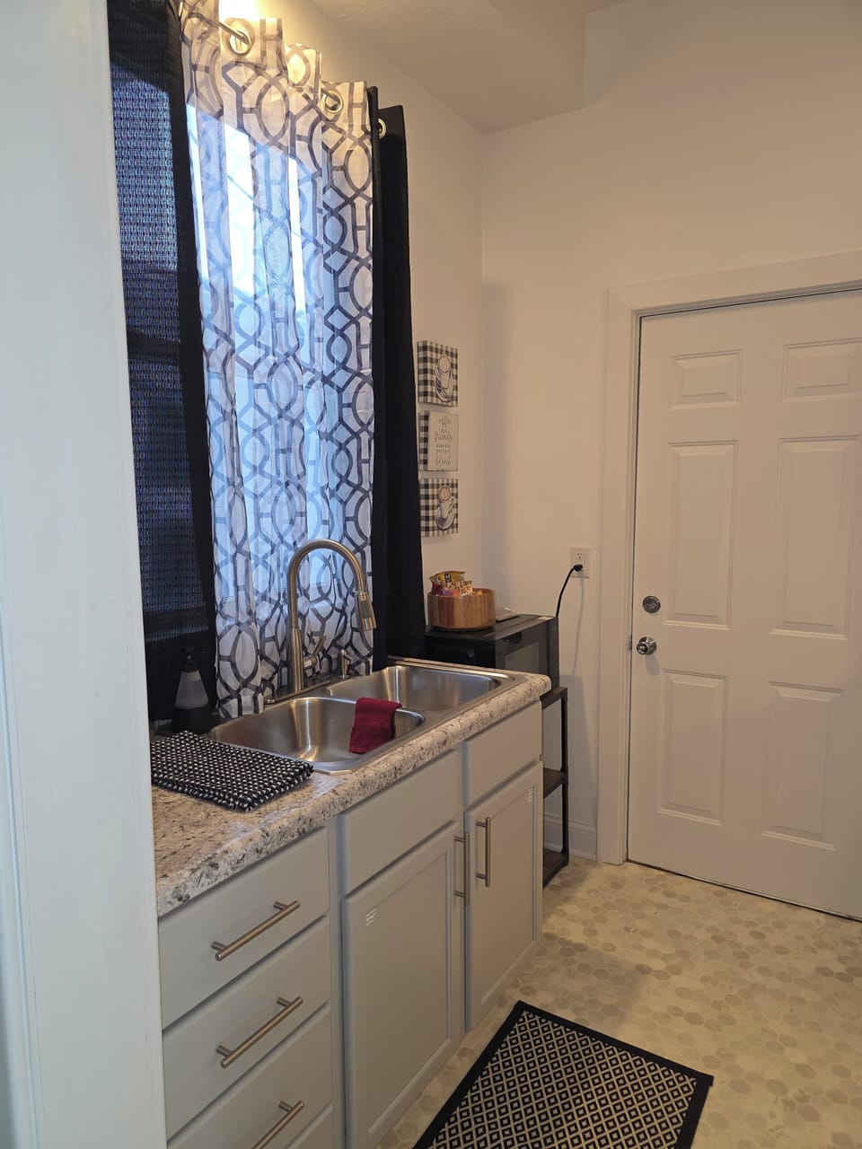 View of kitchen with microwave, toaster, and snack basket.  Back door to deck.