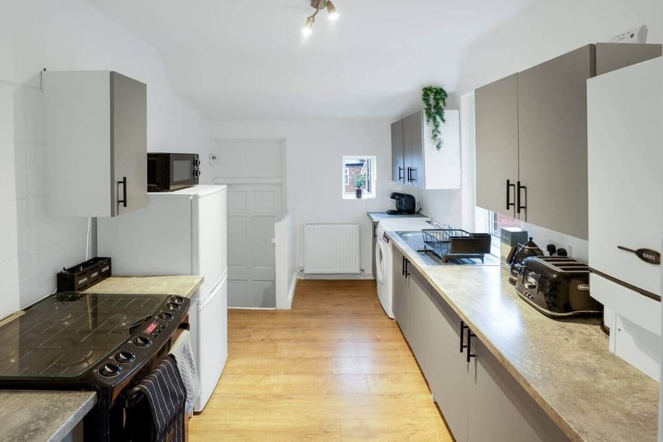 Fully equipped kitchen with everything you need for long stays — washing machine, microwave, gas cooker, coffee machine, toaster, kettle, and full cookware set. Ideal for home-cooked meals.
