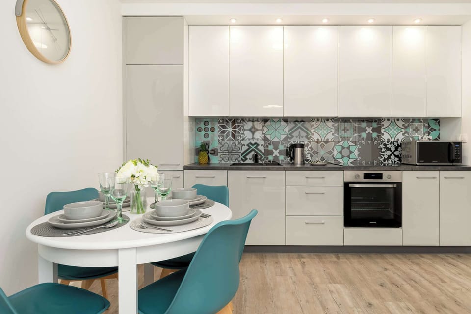A bright kitchen with elegant cabinets and a decorative backsplash creates a space where cooking becomes an enjoyable part of the stay.