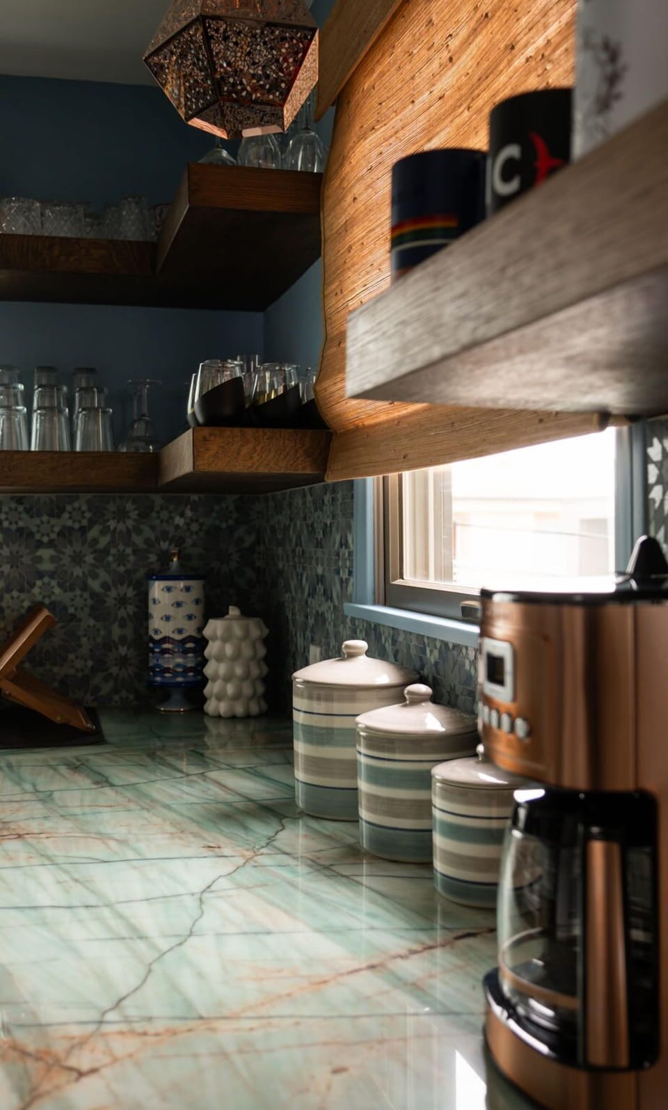 A closer look at the kitchen’s thoughtful details, from artisan canisters to open shelving filled with glassware and charm.