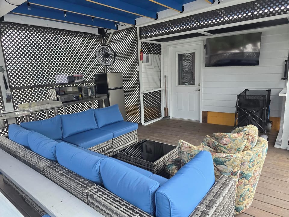 Comfy Seating, Large TV, fan and patio kitchen make the screened patio a great place to hang out.