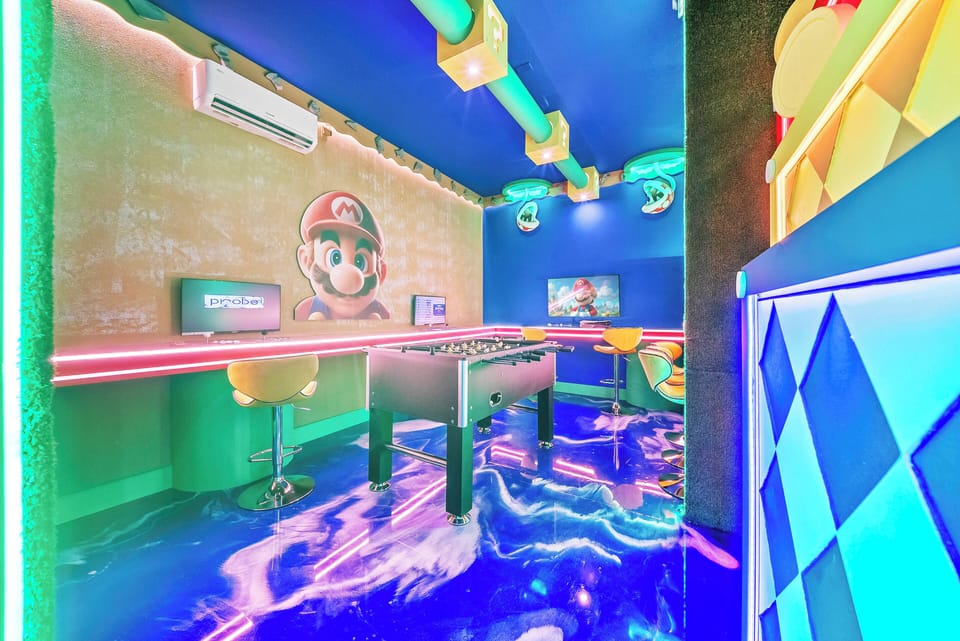 Step into this vibrant game room where colorful murals and playful decor come together for endless fun. The glossy blue floor reflects dynamic lighting, while a foosball table invites friendly competition among guests.