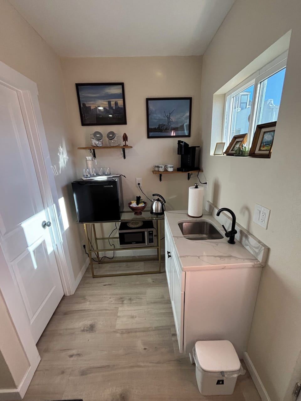 Kitchenette with mini micro, water kettle, Keurig, and sink.
