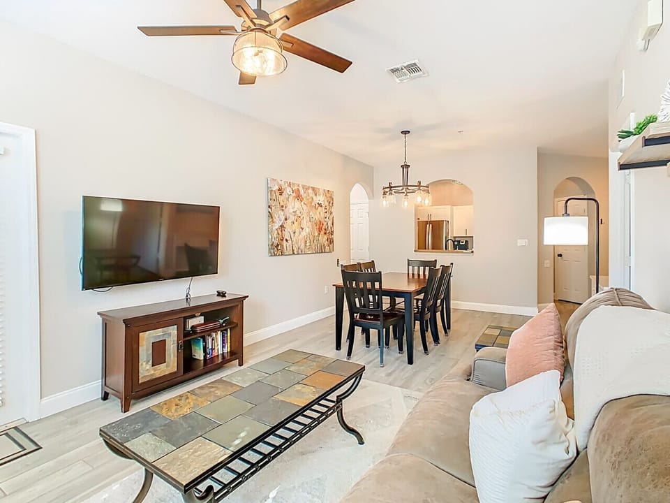 Bright open-concept living and dining space with comfortable seating and a large TV for family relaxation