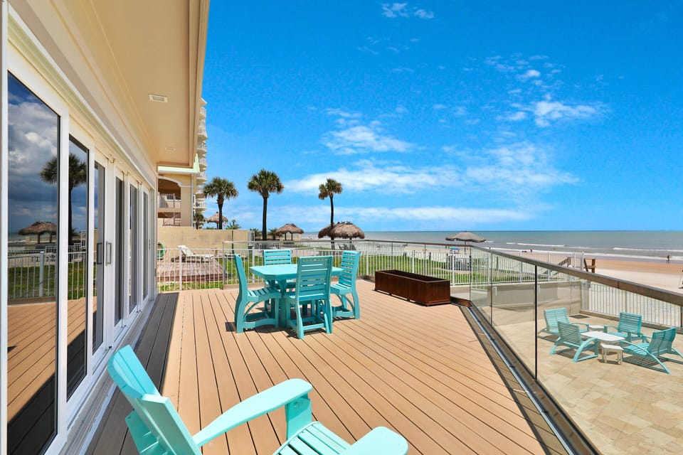 Spacious oceanfront deck perfect for your beach stay! Enjoy stunning shoreline views, bright coastal seating, and relaxing outdoor space just steps from the sand. Ideal for sunbathing, dining, and soaking in the ocean breeze.