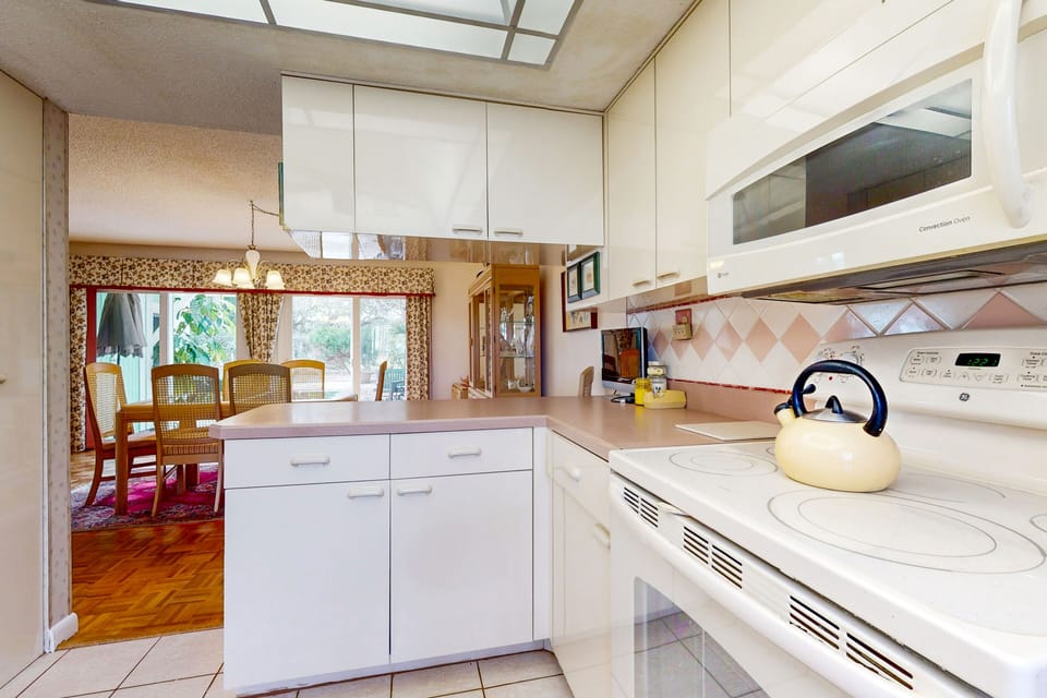 Enjoy an open coastal kitchen and dining layout designed for an easy beach stay. Prepare meals while staying connected with family and friends, making it perfect for laid-back gatherings after a day at the beach.