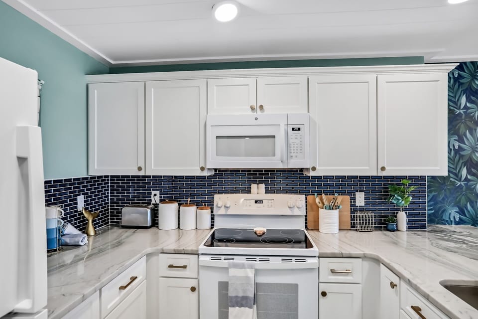 Cook with ease in a fully equipped coastal kitchen featuring modern appliances and beach-inspired finishes. Perfect for your beach stay, this bright space is ideal for preparing meals after sunny days by the ocean.