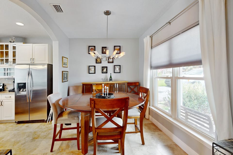Enjoy meals together in this inviting dining space filled with natural light. Conveniently located near the kitchen, it's perfect for family gatherings during your beach stay, offering comfort and a relaxed coastal atmosphere.