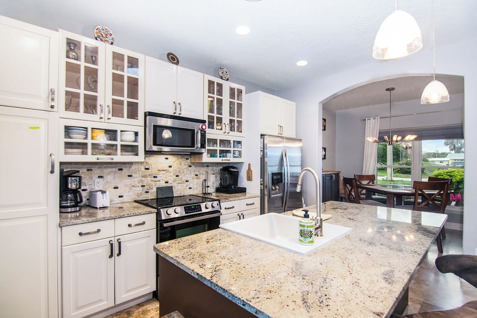 Cook and gather in this spacious coastal kitchen with granite countertops and stainless steel appliances. Designed for easy living, it's perfect for a beach stay where comfort, style, and shared moments come together.