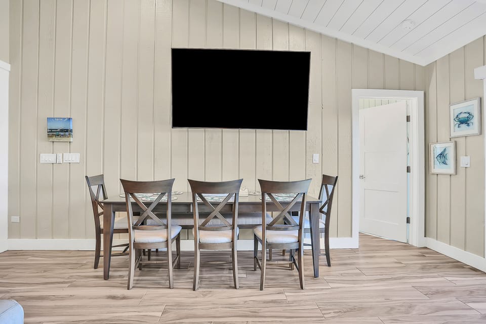 Gather around this casual coastal dining table, perfect for family meals and game nights during your beach stay. With comfortable seating and a relaxed layout, it's an inviting spot to unwind after beach adventures.