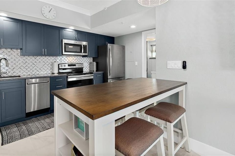 Gather in this open-concept kitchen featuring a spacious dining island and modern appliances. Ideal for a relaxed beach stay, it's perfect for meals, planning coastal adventures, and unwinding after the beach.