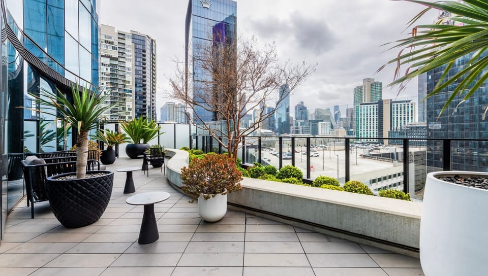 Large private balcony with outdoor seating and stunning skyline panorama.