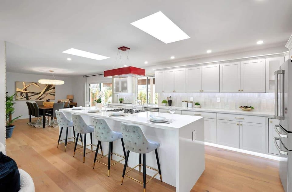 Fully equipped kitchen with stainless steal appliances, LED lighting, and a kitchen island with bar seating for 4 guests.