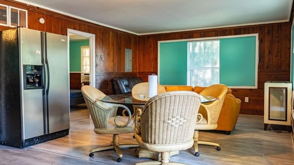 Dining and living area with sofa, table, refrigerator, and seating