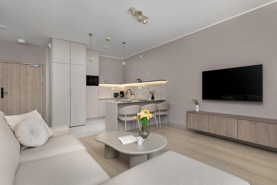 Living room with a large sofa, TV unit, and elegant neutral tones.
