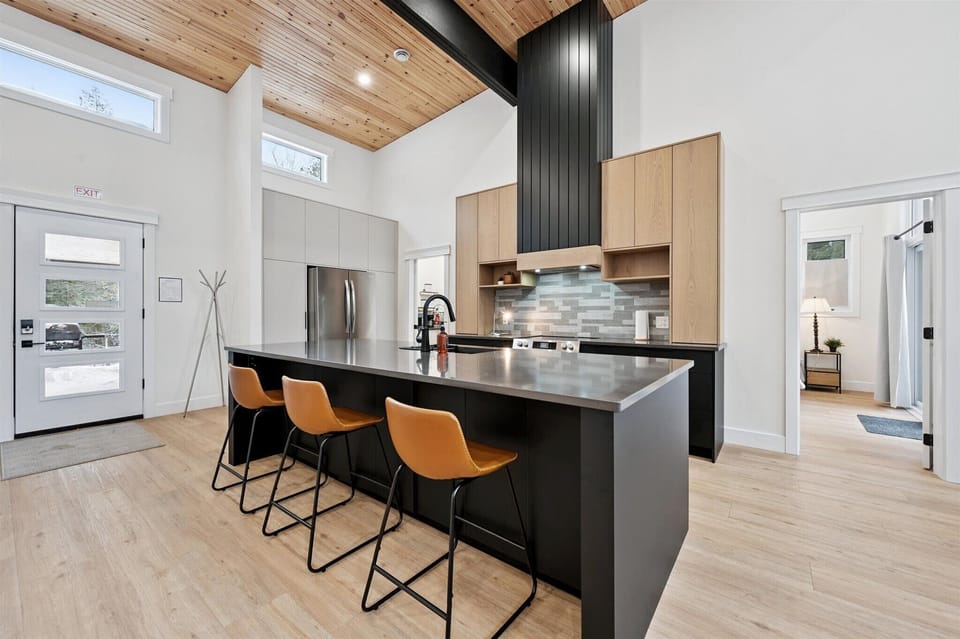 Chef’s kitchen with island seating offering modern appliances, generous prep space, and seating for casual meals.