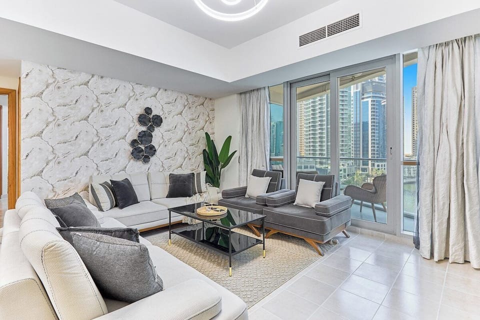 Relax in style! This elegantly furnished living room offers a comfortable sofa set, a large TV, and direct access to the balcony for stunning views.