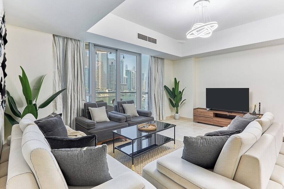 Relax in style! This elegantly furnished living room offers a comfortable sofa set, a large TV, and direct access to the balcony for stunning views.
