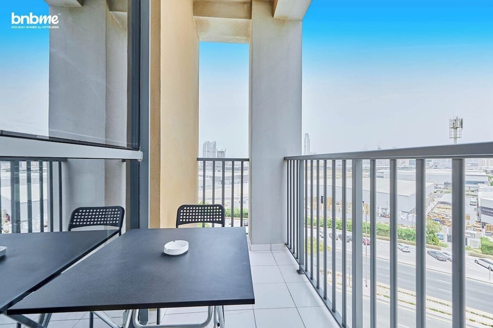 Private balcony with outdoor seating for two, perfect for enjoying morning coffee or evening drinks. Offers open road &amp; city views and a refreshing breeze, creating a relaxing spot to unwind after exploring Dubai.