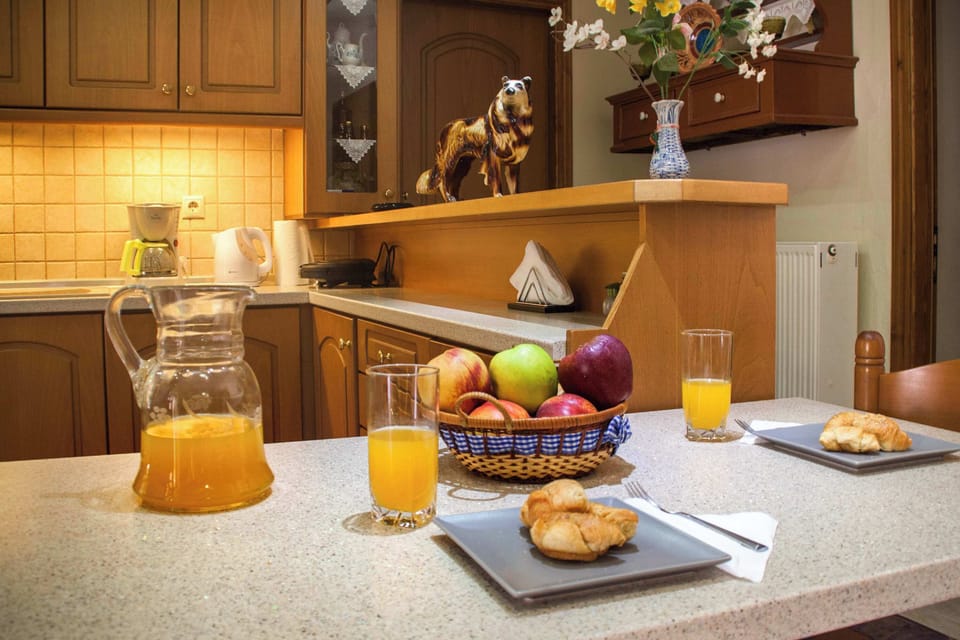 Functional kitchen with wooden cabinetry and dining space, equipped for preparing meals.