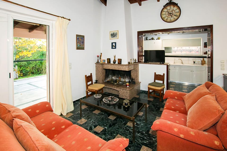 Traditional living room featuring a classic stone fireplace, ideal for cozy evenings and year-round comfort