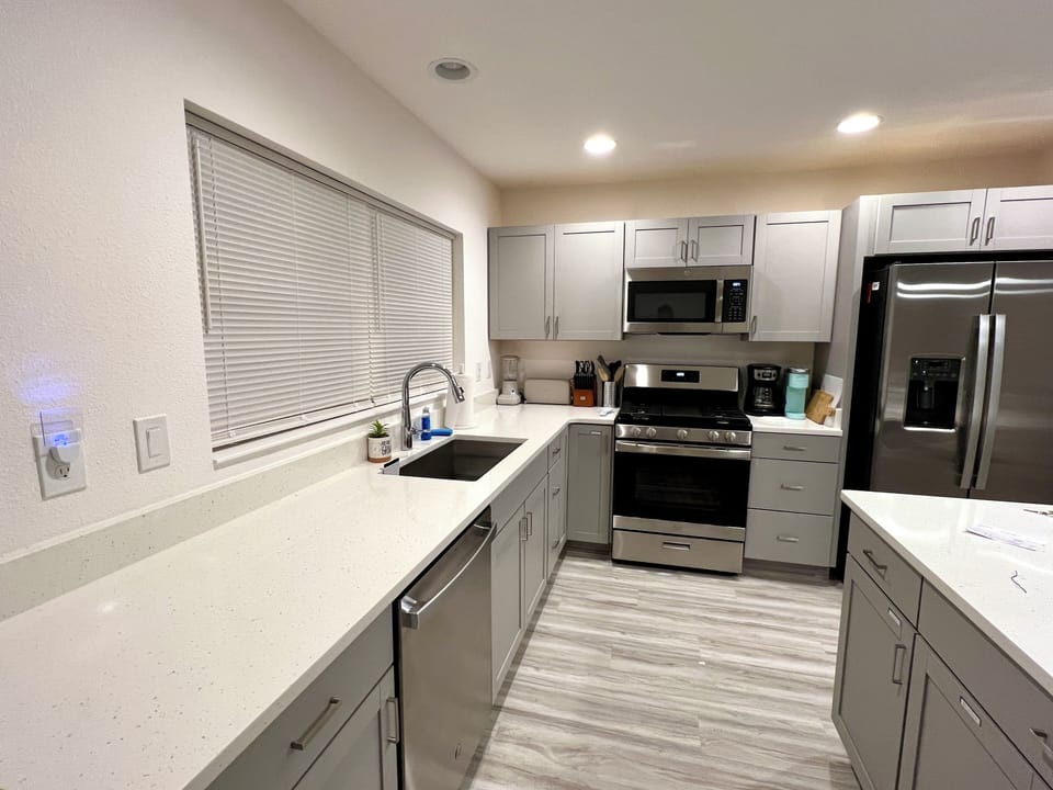 Large kitchen with island, quartz counters, gas range
