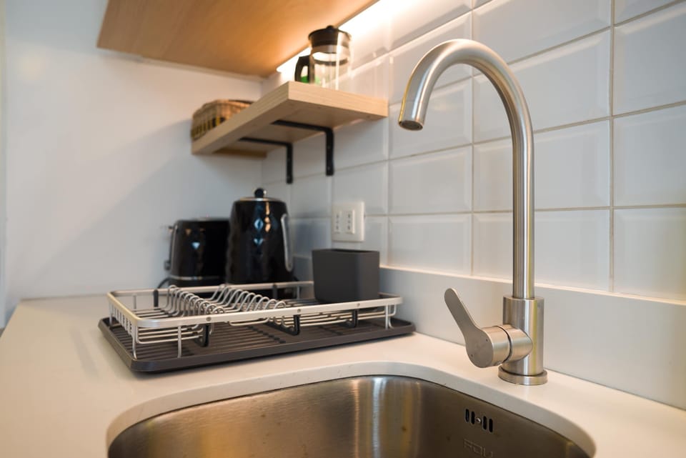 Modern kitchenette with sleek appliances and stylish shelving, perfect for a cozy meal in.