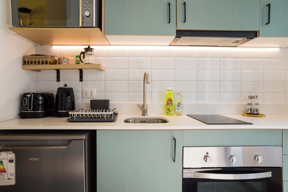 Modern kitchen with essential appliances and sleek design, perfect for preparing meals during your stay.