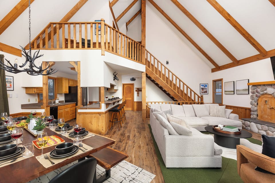 Open-concept living space w/ vaulted ceilings and floor-to-ceiling window views.