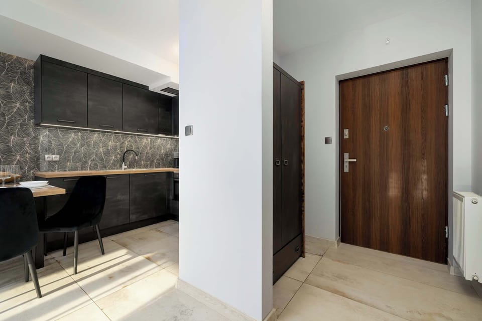 A small entry corridor with wooden doors and bright lighting leading toward the main living spaces.