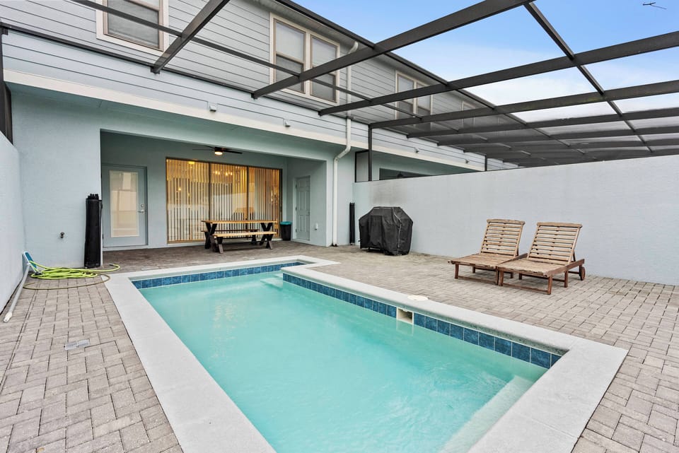Step outside to your private oasis featuring a sparkling pool framed by elegant pavers and a spacious outdoor seating area. Enjoy the gentle breeze as you relax on the comfortable loungers, all beneath a stylish overhead canopy.